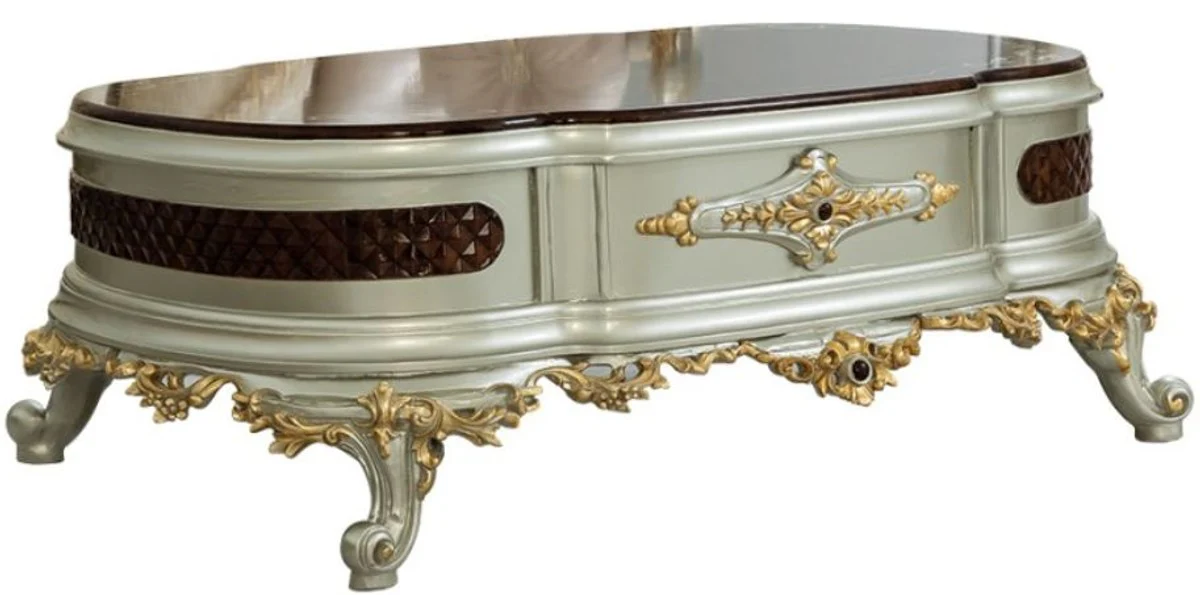 Luxus Barock Couchtisch Dunkelbraun / Silber / Gold 132 x 95 x H. 50 cm - Prunkvoller Massivholz Wohnzimmertisch - Barock Möbel